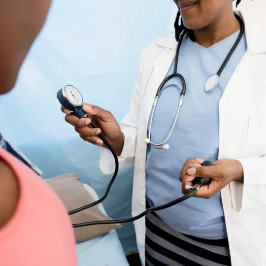 A doctor taking the blood pressure of a patient